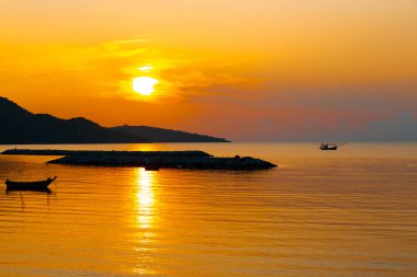 Golden Sunrise sabah deniz üzerinde parlayan ve plaja yakın balıkçı teknesi.