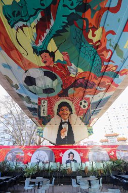 Arjantin Belgrano viyadük altında canlı bir duvar resmi, bir Çin ejderhası ve Diego Maradona 'nın portrelerinin yer aldığı, kültürel birleşmeyi kutlayan.