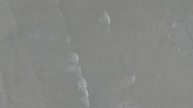 İHA görüntülerinden hava görüntüsü, geri çekilen ve bulanık sahildeki küçük dalgalar..