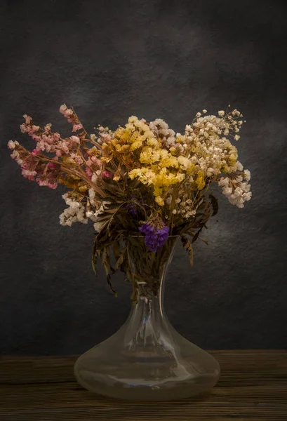 Bouquet of dried flowers forgotten in the loft on dark background