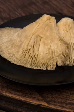 siyah bir tabakta baş aşağı yetiştirilen mantarlar