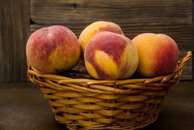 Rustik arka planda hasır sepette şeftali