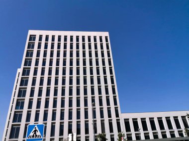 mavi gökyüzü üzerinde bina yanında yaya geçidi işareti