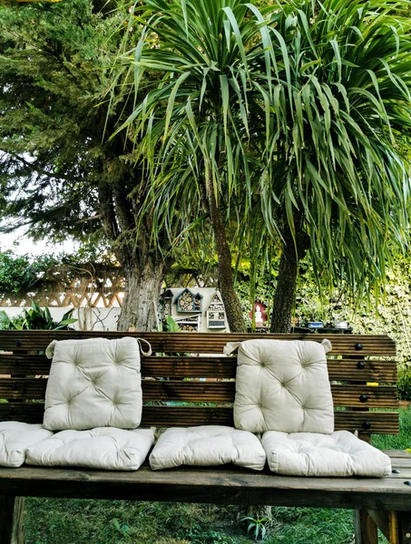 wooden bench with cushions in the garden