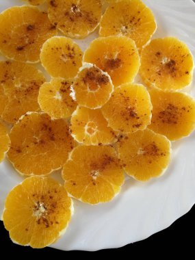 beyaz bir tabak tarçın ile kırmızı portakal