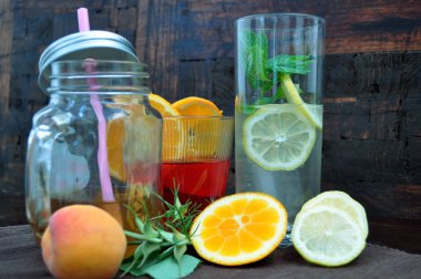 Serinletici içecekler meyveleri ve eski bir ahşap zemin üzerinde otlar ile gözlük