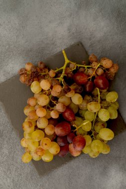 Kayrak Taşı ve gri arka plan üzerinde Olgun üzüm demet