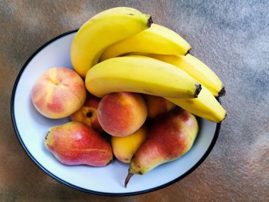 armut, muz ve şeftali yukarıdan görülen kase