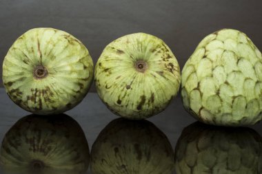 Muhallebi elması, dar arkaplanda yansımalı tropikal meyveler.