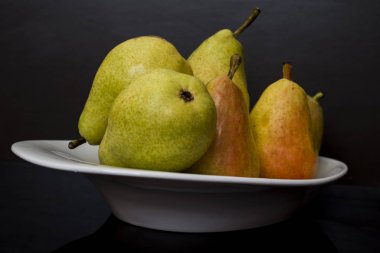 Çekici ve taze armutlar beyaz tepside