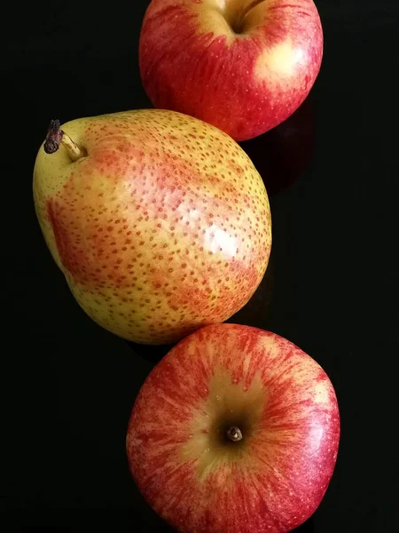 梨子和苹果在黑色背景上闭合在一起 — 图库照片