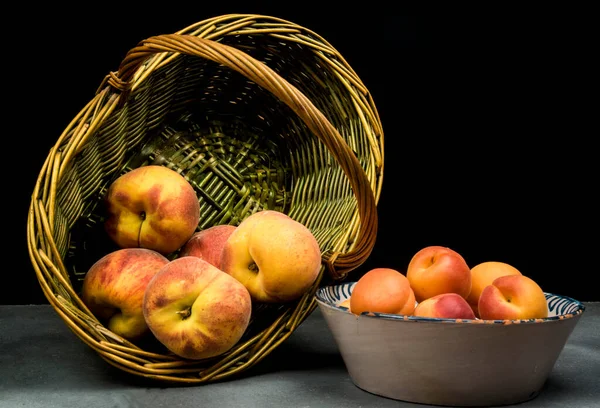 Aprikosen Auf Keramikschale Und Pfirsiche Auf Weidenkorb — Stockfoto