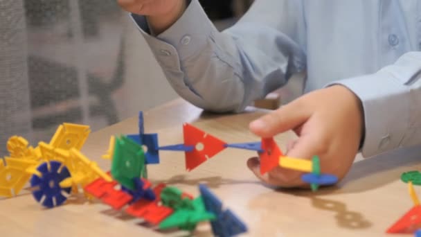 Руки неизвестного мальчика, играющего со строительным комплектом — стоковое видео