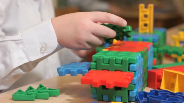 Manos de niño desconocido jugando con kit de construcción — Vídeo de stock