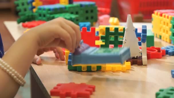 Руки невідомої дитини, що грає з будівельним комплектом — стокове відео