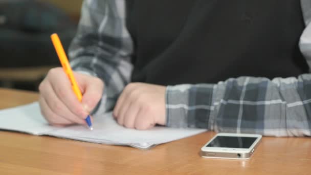 Onbekende student schrijft tekst met behulp van de pen in notitieblok — Stockvideo