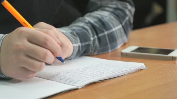 Onbekende man schrijft tekst met behulp van de pen in notitieblok — Stockvideo