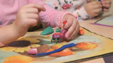 Bilinmeyen küçük çocuk masa başında oturan farklı rakamları renkli modelleme hamuru odasında yapılmış sculpts. Modelleme çocuklarda sanatı gelişimi