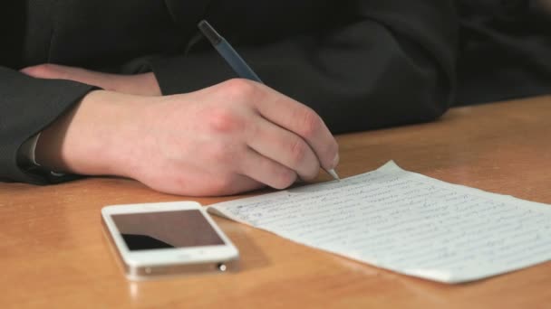 Студент пишет текст ручкой в документе — стоковое видео