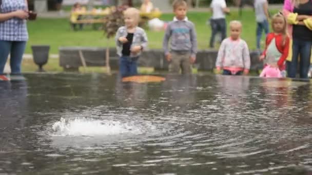 Jongetje gooien munten geld in het midden van de fontein — Stockvideo