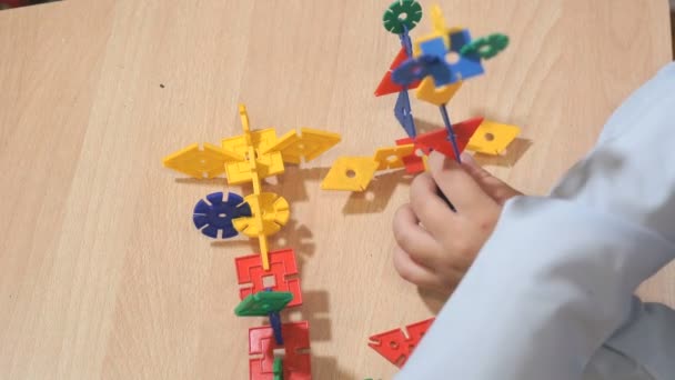 Руки неизвестного ребенка, играющего со строительным комплектом — стоковое видео