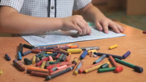 Хлопчик малює картини, використовуючи кольорові чаші та олівці — стокове відео