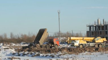 Turuncu inşaat kamyonu kil taşıyor