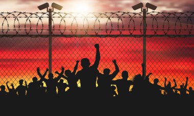 Enraged crowd of people are behind bars. Fence wire mesh barbed wire, vector silhouette. Street camera on the pillar. Sunset background. (Clipping Mask) clipart