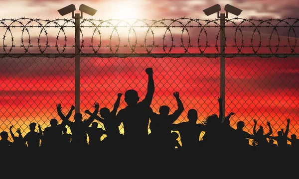 Enraged crowd of people are behind bars. Fence wire mesh barbed wire, vector silhouette. Street camera on the pillar. Sunset background. (Clipping Mask)