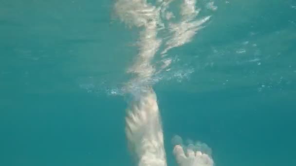 Az ember lába víz alatt. A tengervíz felszínén. Lassított mozgás. — Stock videók