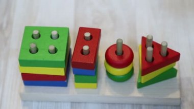 Bebek tahta bir yapıcı, yavaş hareket pin bir daire koyar. Bir yaşındaki çocuğun eli ve oyuncak, yakın