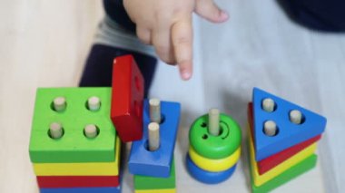 Bir yaşındaki çocuk (erkek) geometrik ayırıcı (ahşap yapıcı), çocuk eli ve oyuncak yakın çekim, 50 fps, yavaş hareket ile oynar
