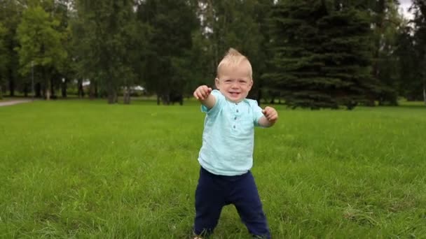 Primeros pasos del niño en pleno crecimiento, al aire libre. Etnia blanca. Movimiento lento — Vídeos de Stock