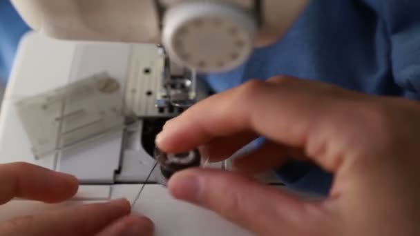 Заполнение кабинки ниткой в швейной машинке. The woman 's hand run lower thread in sewing machine — стоковое видео