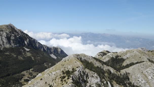 Hvite skyer flyter mellom fjelltoppene. Lovcen nasjonalpark, Montenegro. Tidsforfall . – stockvideo
