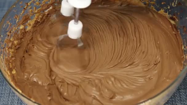 Kokt kondenserad mjölk och gräddfil vispas med mixer i en glasskål, närbild — Stockvideo