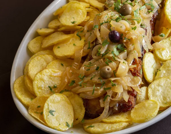 有洋葱和马铃薯片的炸鳕鱼 也被称为 Bacalhau Recheado 是葡萄牙最有名和典型的菜肴之一 — 图库照片