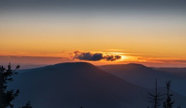 Çek Cumhuriyeti 'nde Moravskoslezske Beskydy Dağları' nda Lysa Hora Tepesi zirvesinden gelen az bulutlu ve renkli gökyüzü ile gün batımı