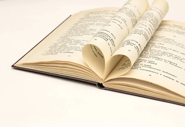 Kalp şeklinde bir sayfa ile beyaz bir arka plan üzerinde açık kitap