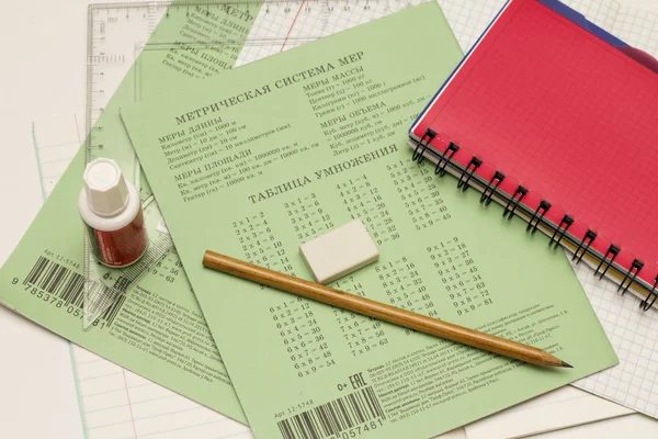 Kırmızı defter, kalem, defter, silgi ve beyaz arka plan üzerinde cetvel