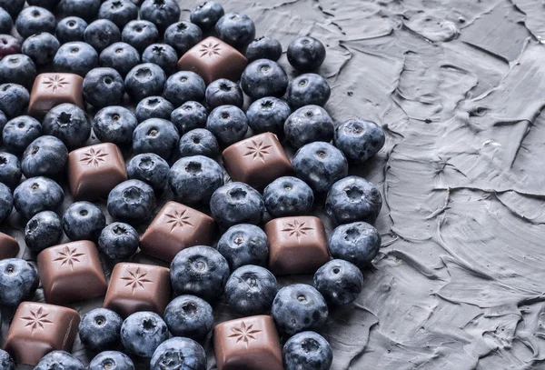 gri bir arka plan üzerinde yaban mersini ve çikolata çok