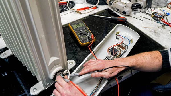 atölyede bir adam farklı araçları ile ekipman tamir