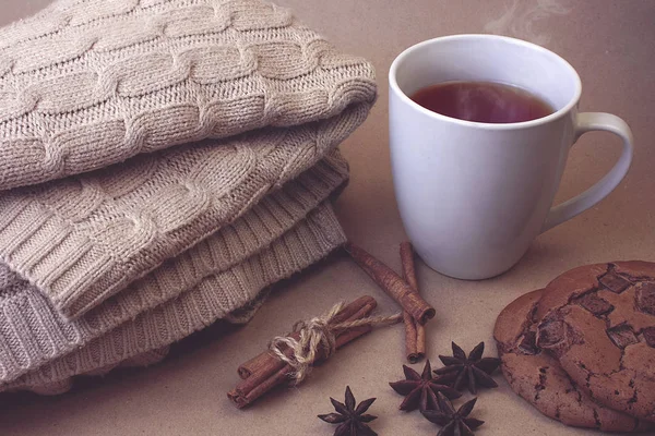 Sıcak çay Fincan, kurabiye ve kahverengi Kraft arka plan üzerinde sıcak kış eşarp örme