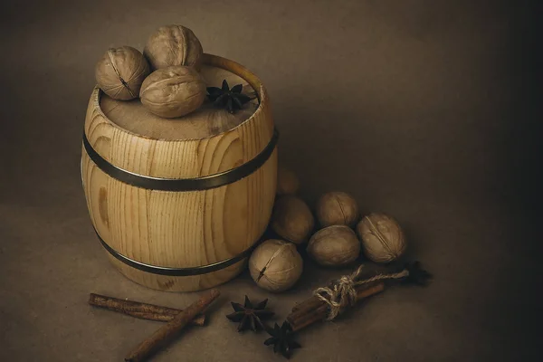 Ceviz, ahşap varil, tarçın ve kahverengi bir arka plan üzerinde yıldız anason.