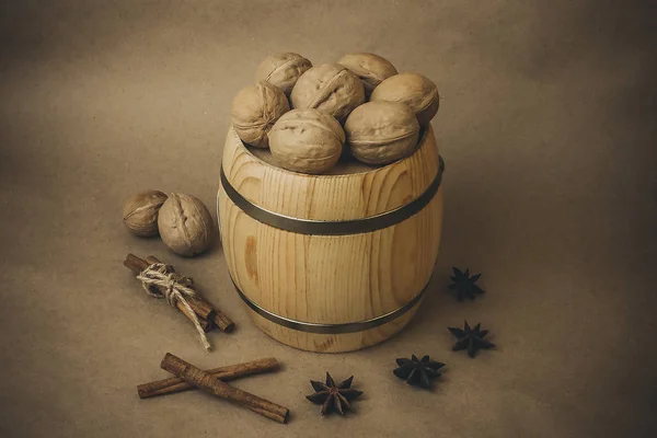 Ceviz, ahşap varil, tarçın ve kahverengi bir arka plan üzerinde yıldız anason.