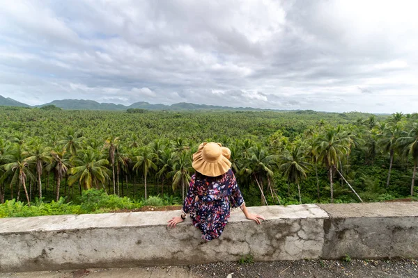 Siargao'da hindistan cevizi tarlası arayan bir kadın.