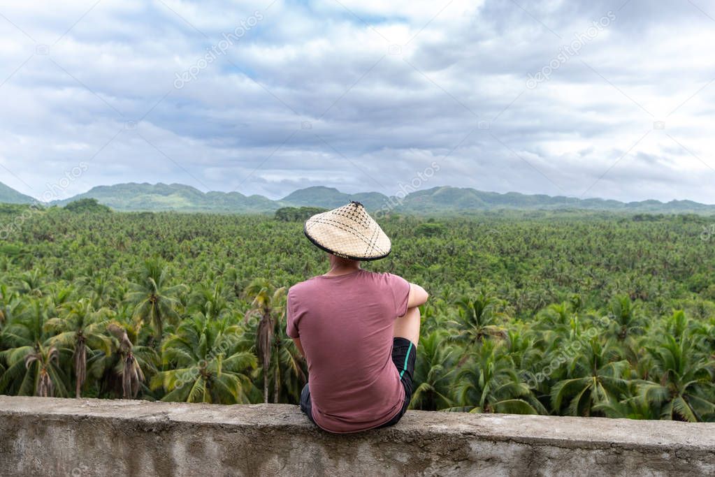 A man looking at a coconut plantation in Siargao