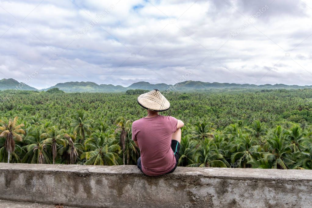 A man looking at a coconut plantation in Siargao