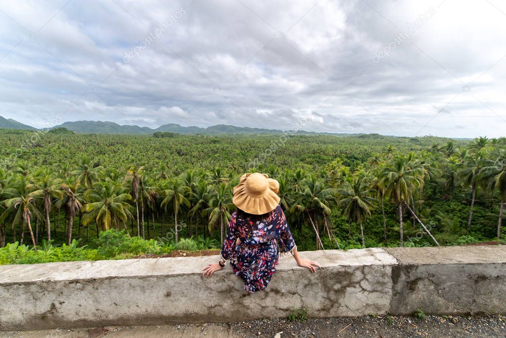 A woman looking at a coconut plantation in Siargao