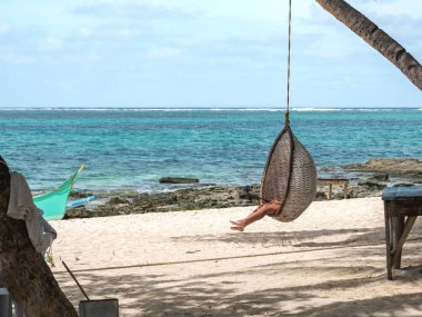 Bir kadın bir hamakta uzanıp mola veriyor.